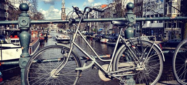 Bicicleta frente a un canal en Ámsterdam
